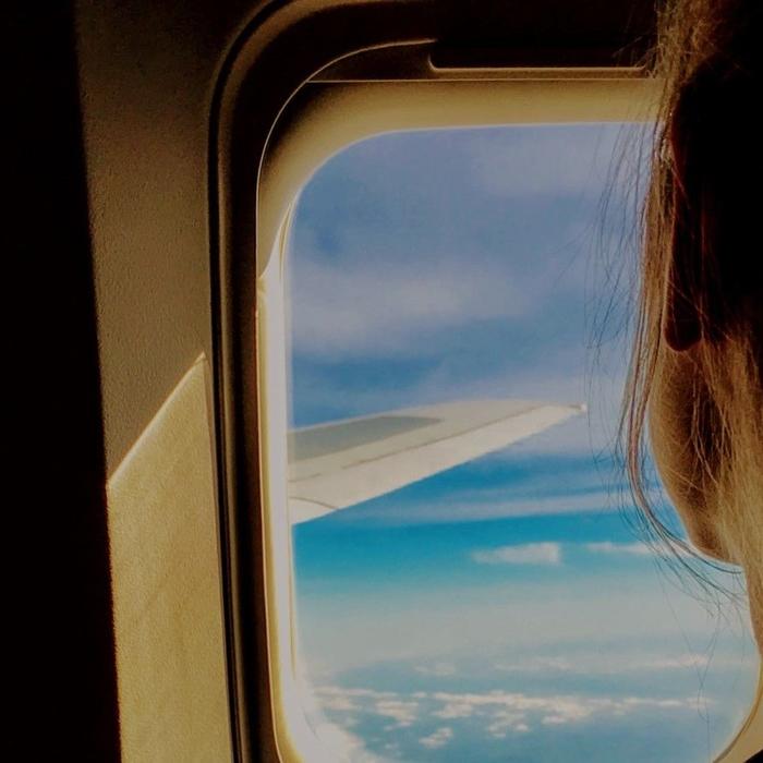 a woman looks out an airplane window